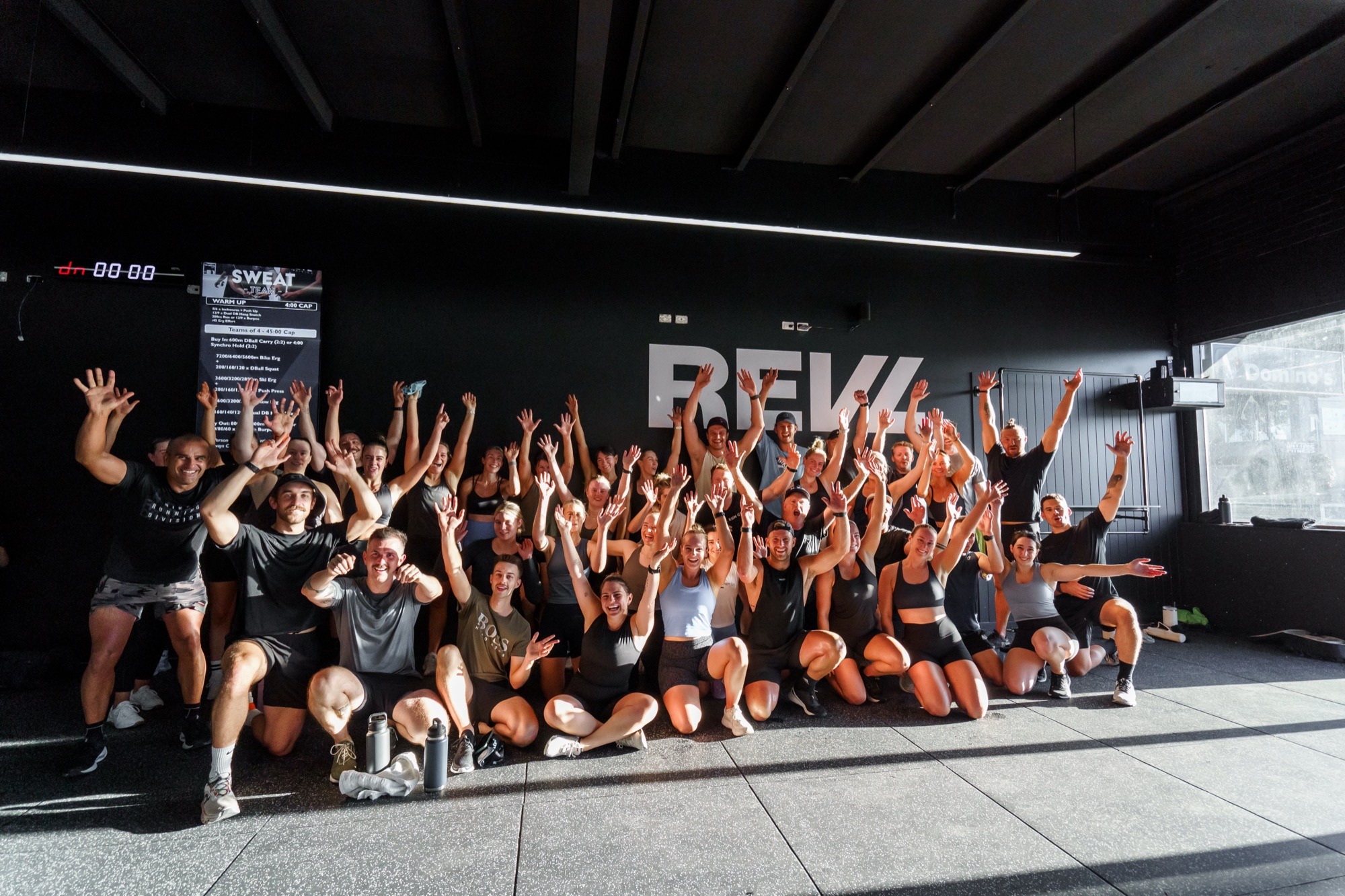 The full REVL class in front of the REVL wall